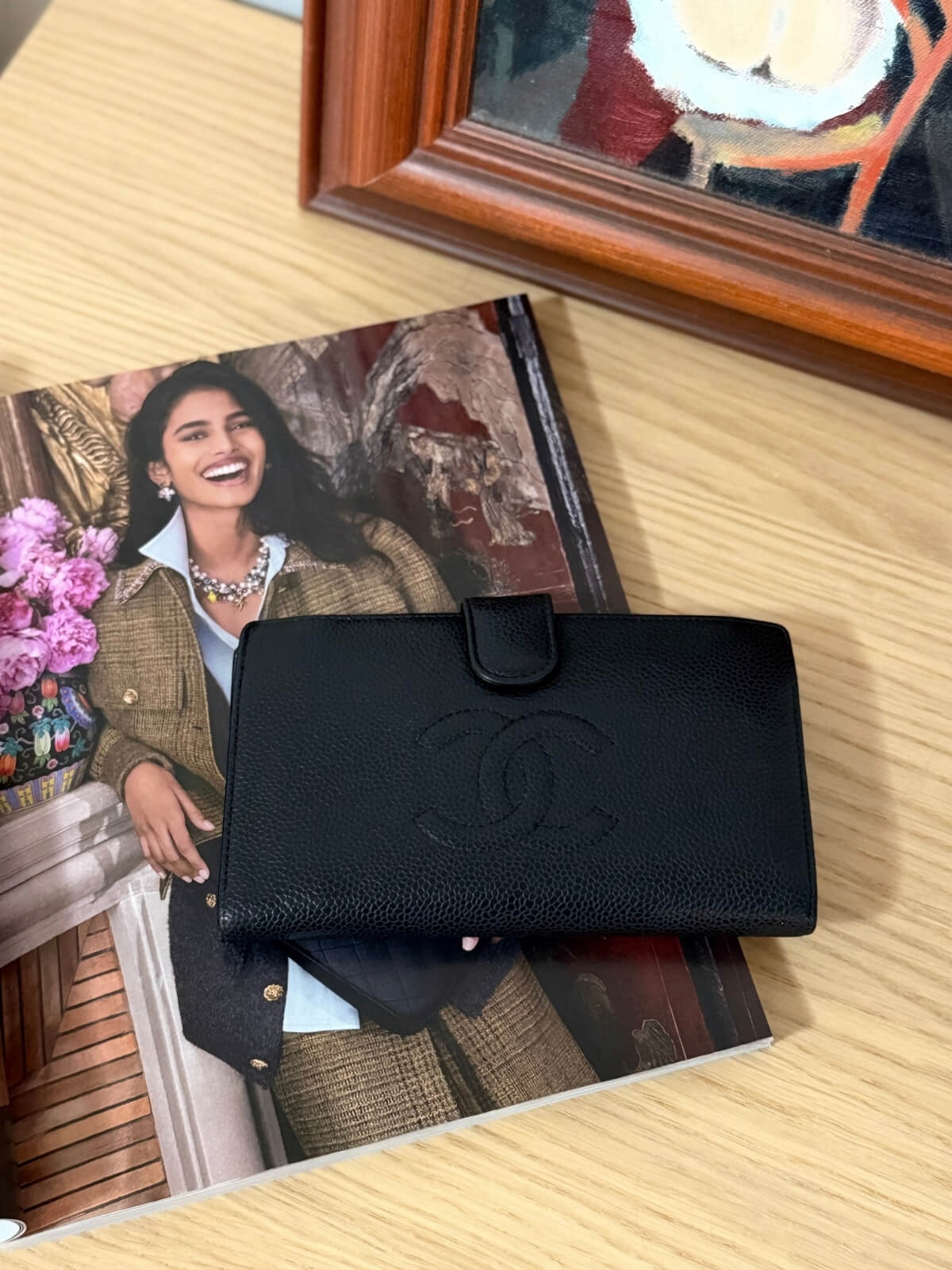 Louise Row featuring vintage Chanel black cavier embossed wallet on table 