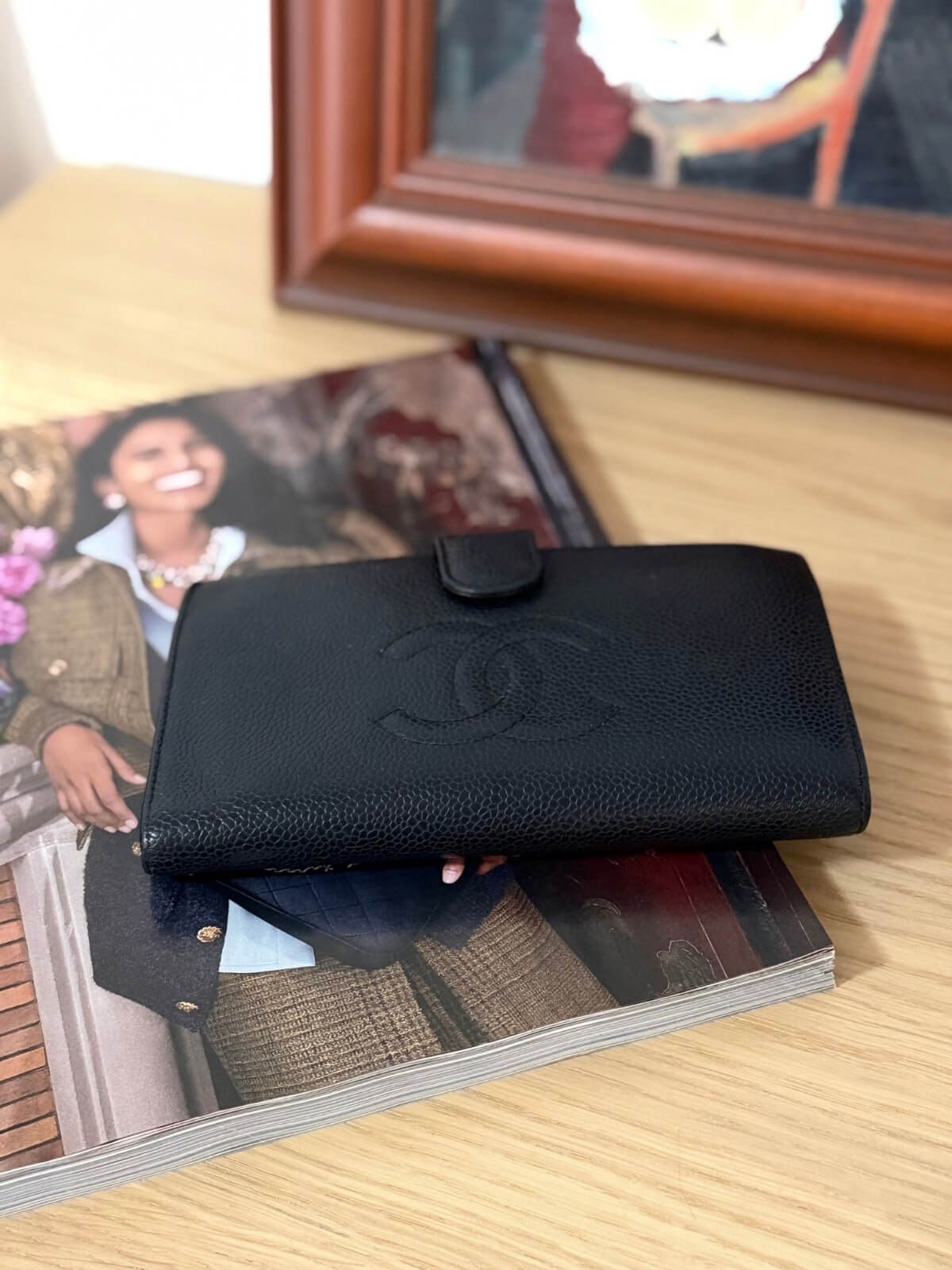 Louise Row featuring vintage Chanel black cavier embossed wallet on table 