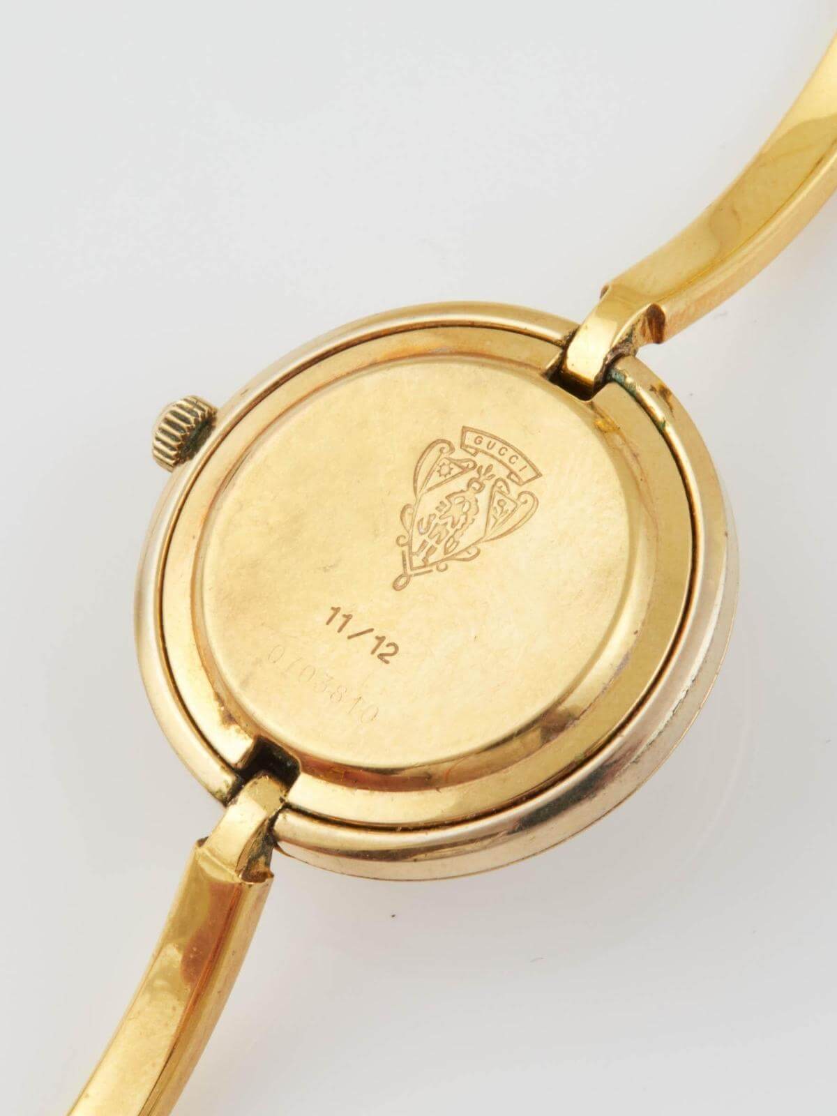 Back of Gucci Gold watch with a visible brand logo on a white background