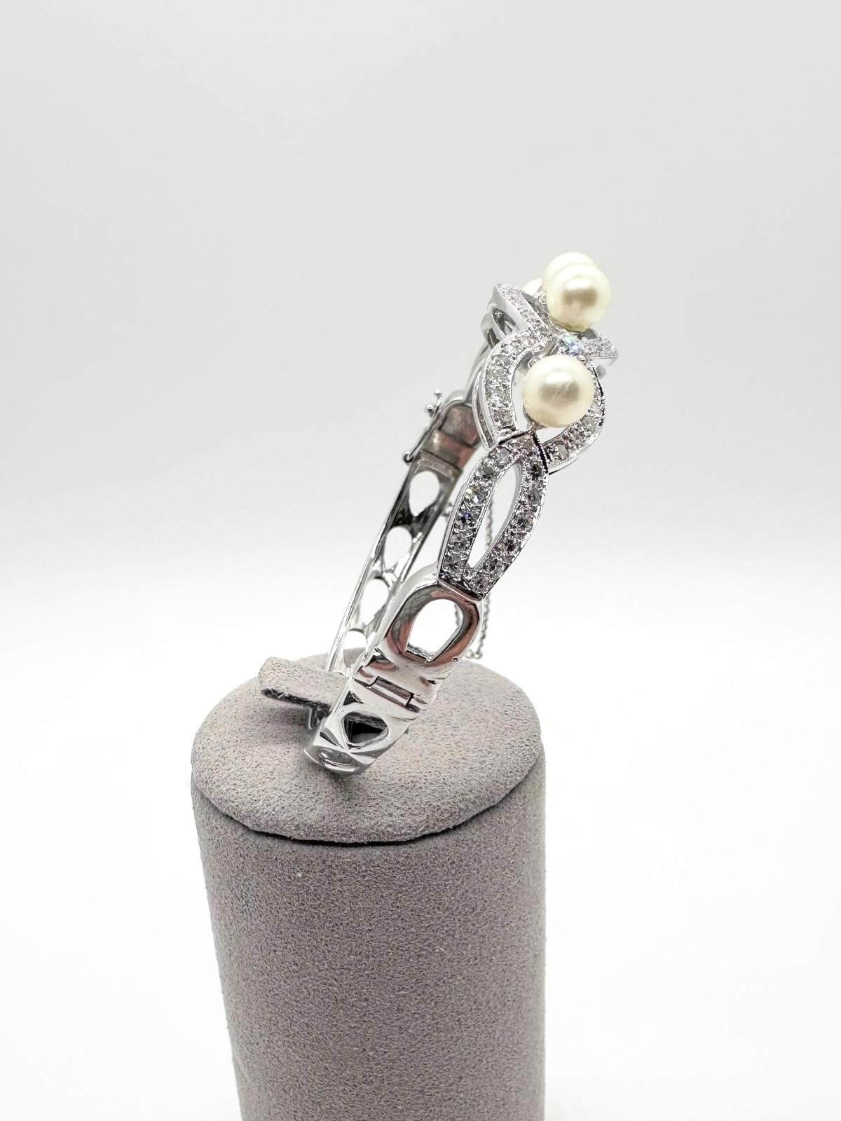  White gold and pearl bracelet on white background on grey fixture